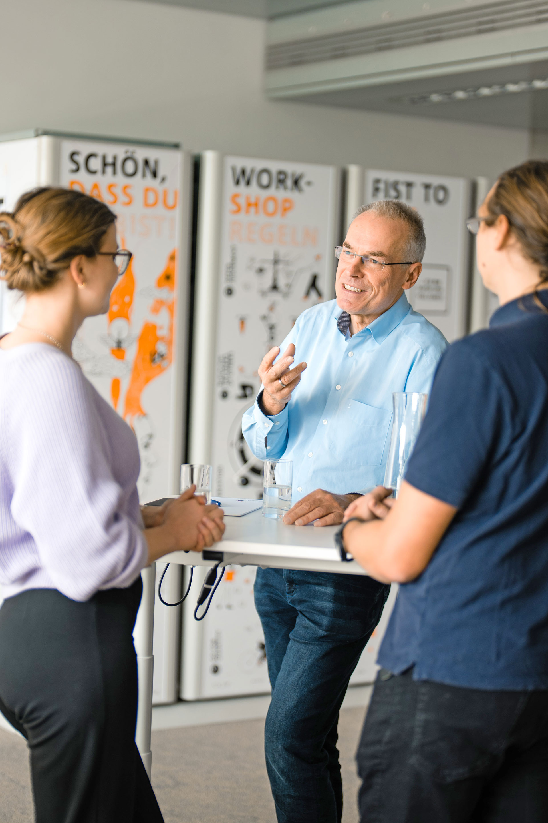 Thomas Renner, Leiter des Forschungsbereichs Digital Business am Fraunhofer IAO, steht mit einer Frau und einem Mann an einem Tisch und ist im Gespräch.