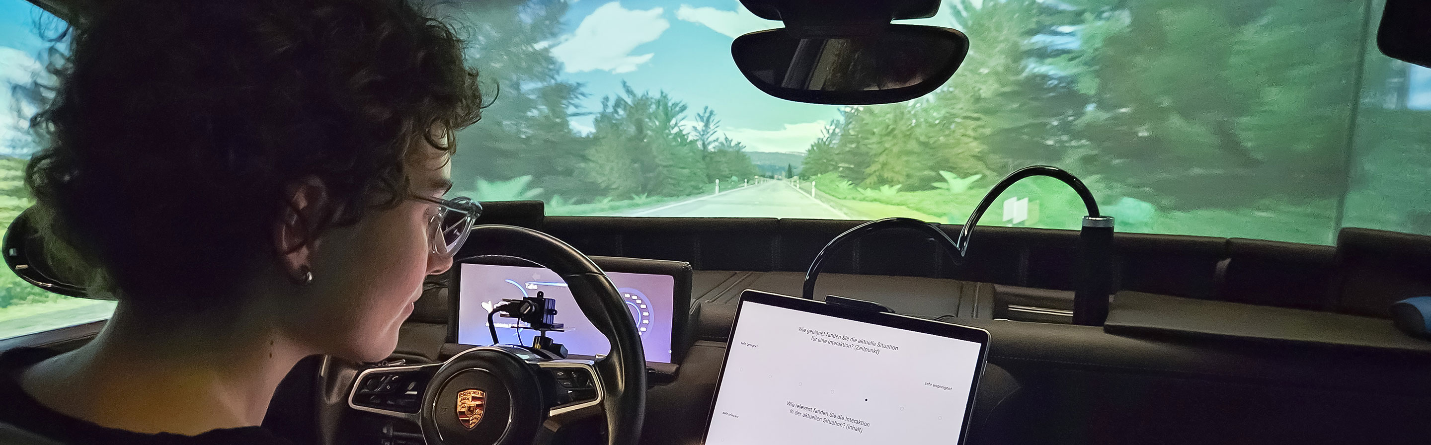 Eine Frau sitzt am Steuer eines Fahrzeugs, das mit viel Elektronik ausgestattet ist.